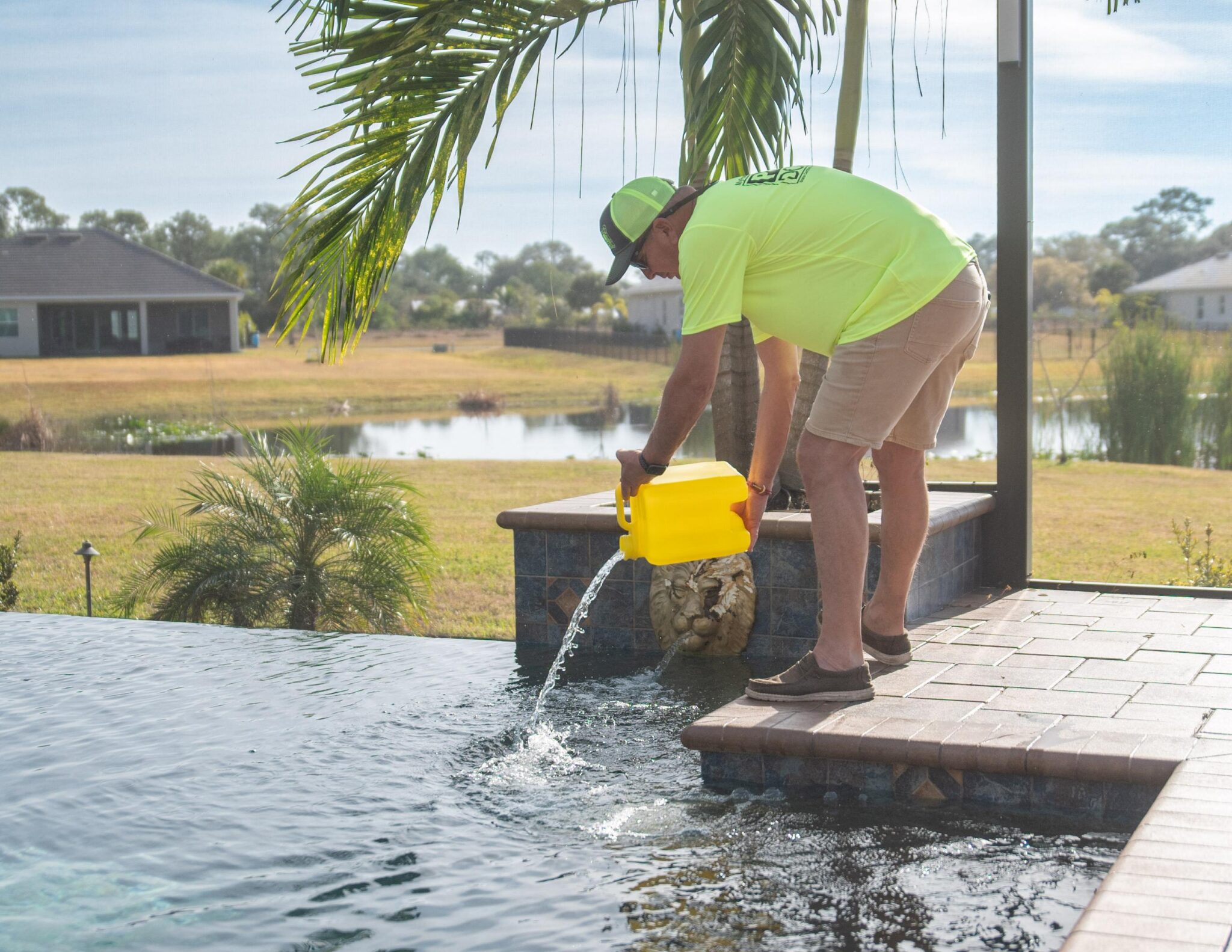 Pool doctor technicians adding chlorine into a swimming pool 
